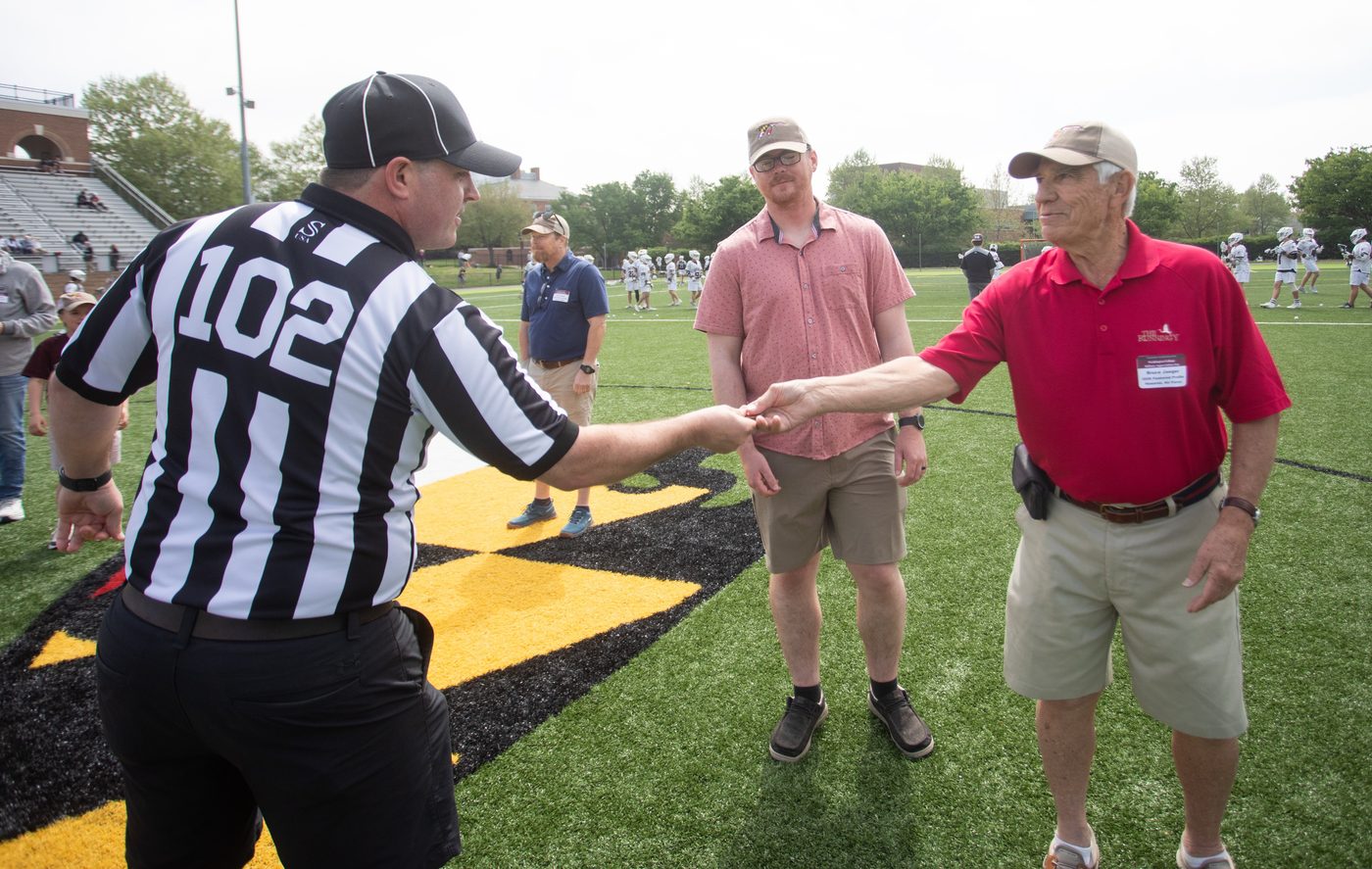 Referee, Bruce Jaeger, and a guest at the ceremonial coin flip